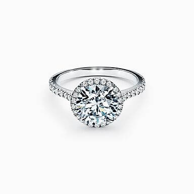 De perfecte verlovingsring kiezen: witgouden ring bezet met briljantjes en een ronde diamant, omcirkeld door kleine diamantjes. 