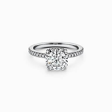 De perfecte verlovingsring kiezen: een witgouden ring bezet met kleine diamantjes op de band en een vierkante steen als diamant. 