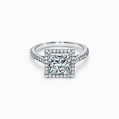 De perfecte verlovingsring kiezen: een withouden band bezet met briljantjes en een vierkante diamant, omringd door kleine diamantjes. 

