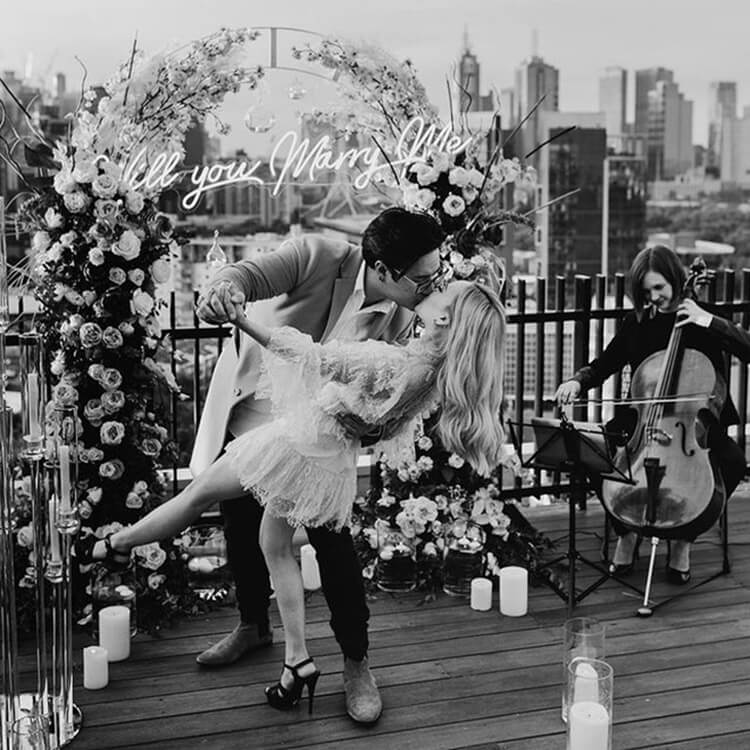 Het perfecte huwelijksaanzoek met een prachtige backdrop op een terras en live muziek. 