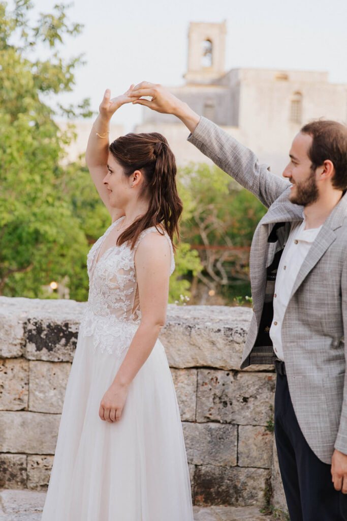 Trouwen in Italië met een bruidspaar dat danst voor een monument. 