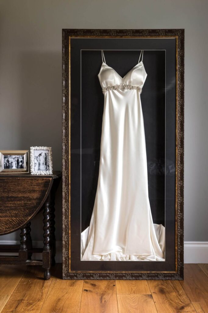 Wat doe je met je trouwjurk na de bruiloft? Ingekaderde trouwjurk die in het interieur van het bruidspaar opgenomen is. 