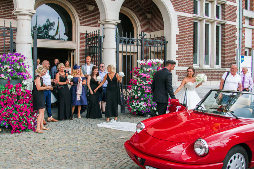 Hoe kan je trouwen voor de gemeente? Het bruidspaar verlaat het stadhuis en stapt in een rode cabrio. 
