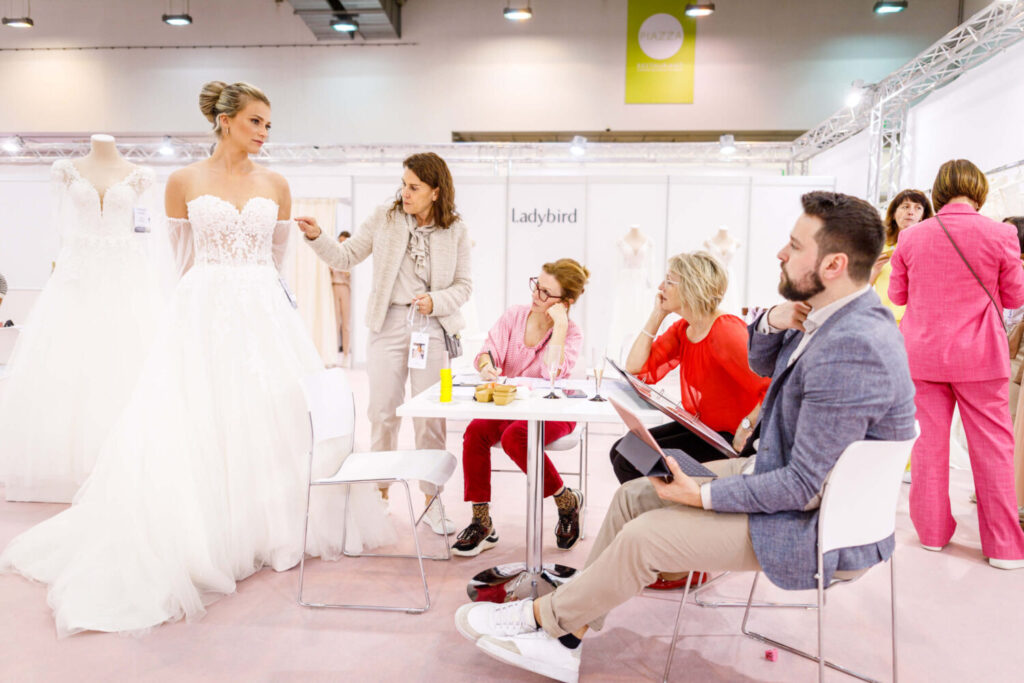 Buyers rating a wedding dress on a model  at European Bridal Week. 