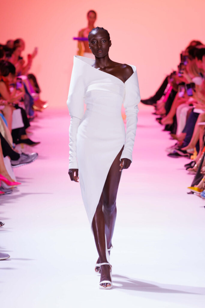 De grootste trends van Paris Haute Couture Week waarbij een model een asymetrische witte jurk met hoge beensplit draagt. 