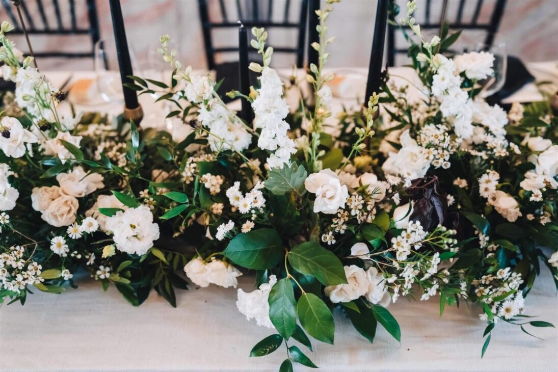 Zwart-witte bruiloft met zwarte decoratie afgewisseld met witte bloemen.